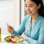 저속노화 다이어트 아침 식단으로 샐러드와 계란 아보카도 견과류를 먹는 건강한 30대 여성